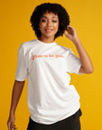 Curly Haired woman wears white Free to be you tee